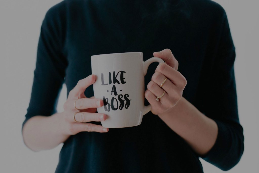 A woman holding a mug that says "Like a Boss" - decoration only