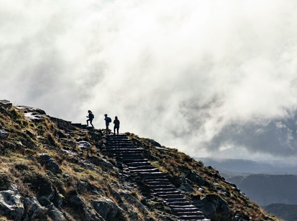 a person leading people to the top of a mountain. Photo by Francois Olwage on Unsplash