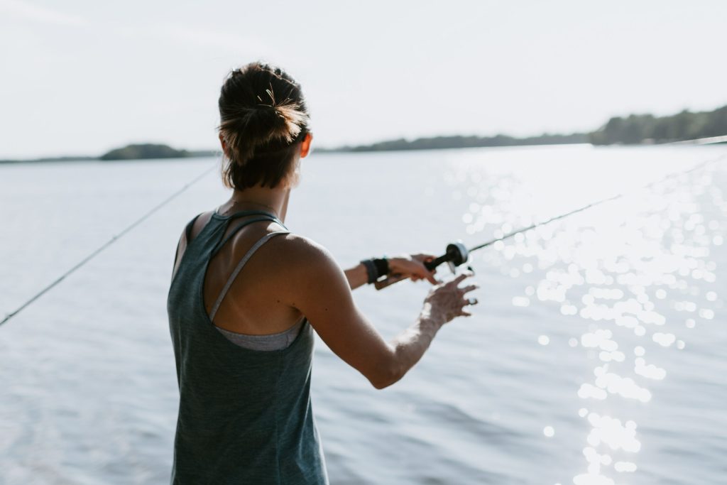 Person holding fishing rod on water