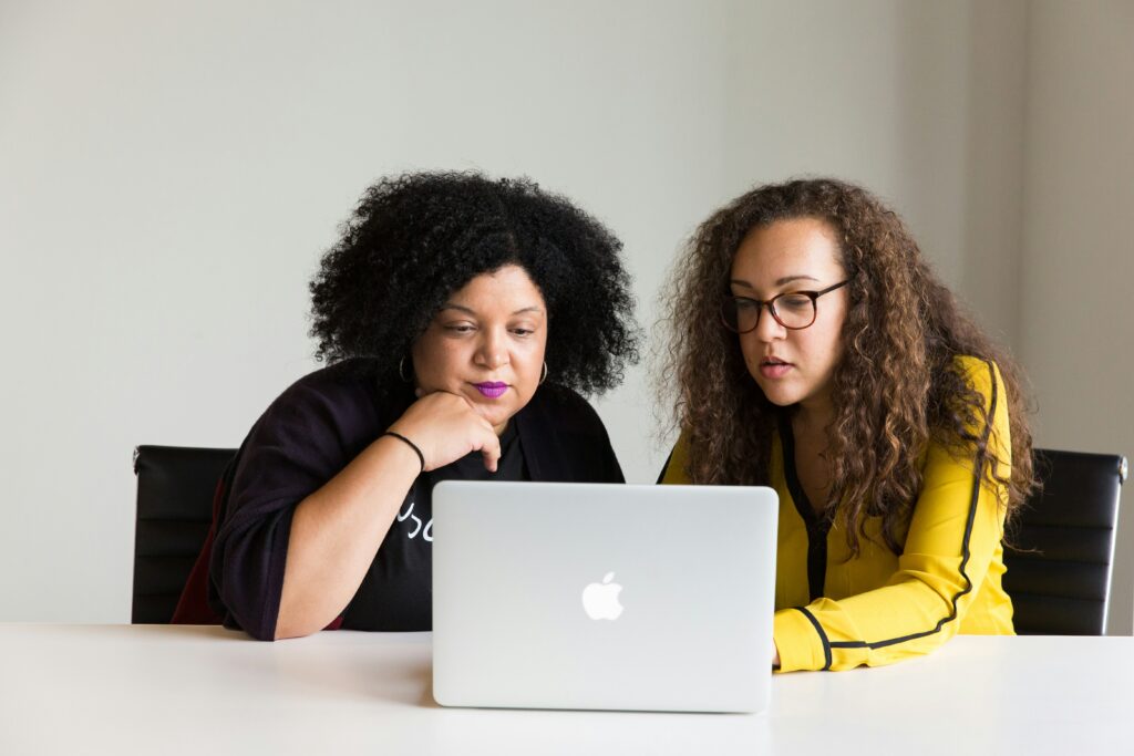 Two women looking at one laptop. Image credit: Christina @ wocintechchat.com on Unsplash